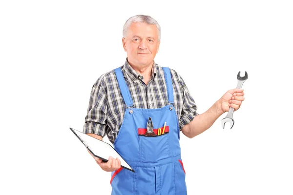 Mechaniker hält Schraubenschlüssel und Klemmbrett — Stockfoto