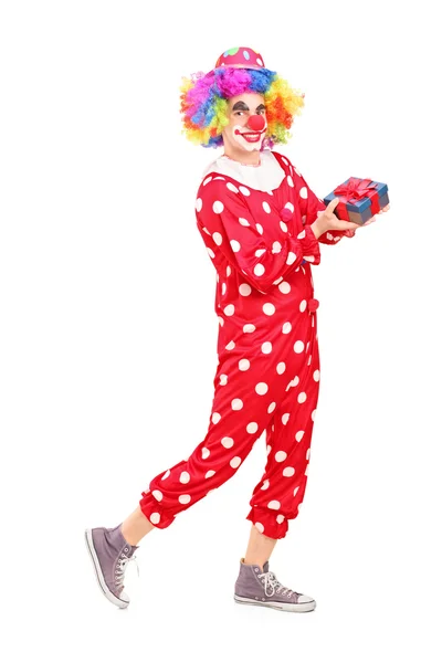 Male clown holding gift — Stock Photo, Image