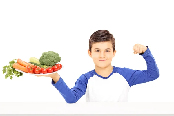 Menino com legumes mostrando músculo — Fotografia de Stock