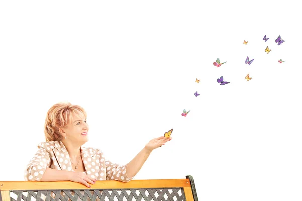 Mulher madura olhando para borboletas — Fotografia de Stock
