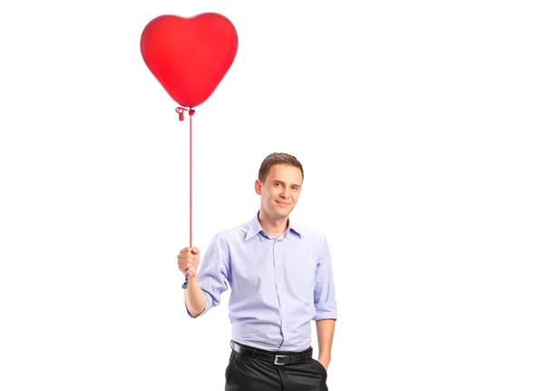 Muž drží balónek ve tvaru srdce — Stock fotografie