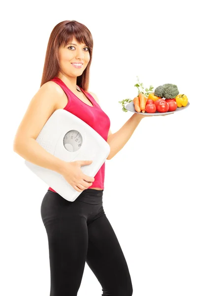 Mujer sosteniendo verduras y peso sc — Foto de Stock