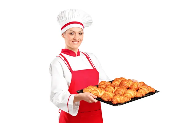 Female baker holding baked croissants — Stock Photo, Image