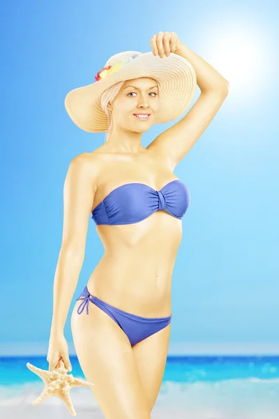 Kvinna i bikini hålla sjöstjärna — Stockfoto