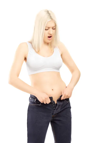 Donna cercando di spremere vecchi jeans — Foto Stock