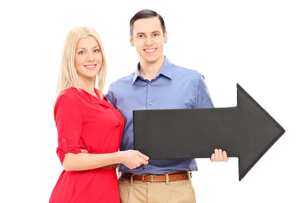 Couple holding black arrow pointing right — Stock Photo, Image