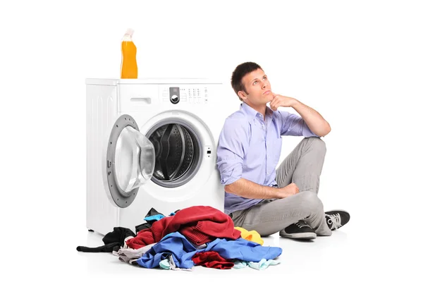 Macho pensativo ao lado da máquina de lavar roupa — Fotografia de Stock