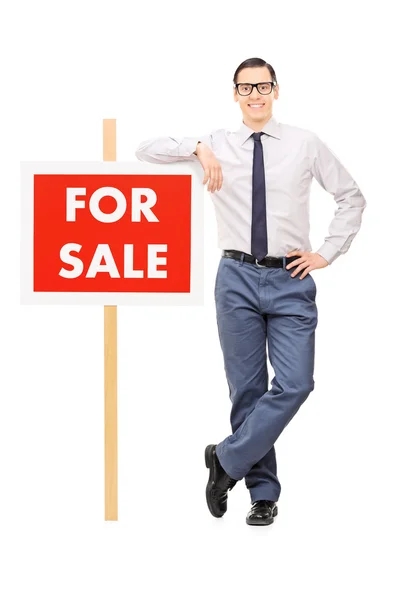 Man leaning on for sale sign — Stock Photo, Image