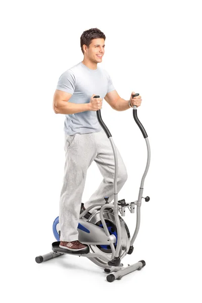 Homem exercitando na máquina cross trainer — Fotografia de Stock