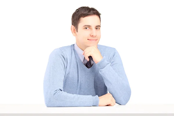 Man posing seated on table — Stock Photo, Image