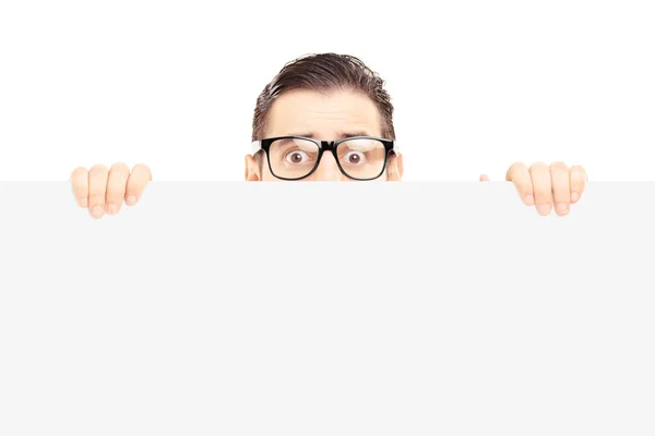 Homem escondido atrás do painel em branco — Fotografia de Stock