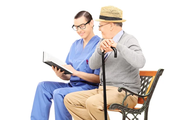 Health care professional reading to gentleman — Stock Photo, Image