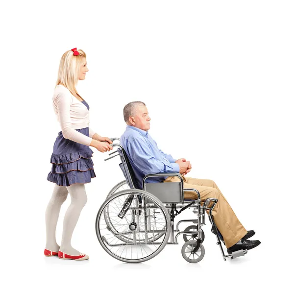 Дочка штовхає тата в інвалідне крісло — стокове фото