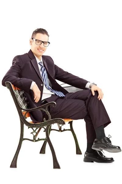 Young man sitting on bench — Stock Photo, Image