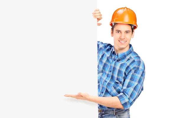 Trabalhador da construção com capacete posando atrás de um painel — Fotografia de Stock