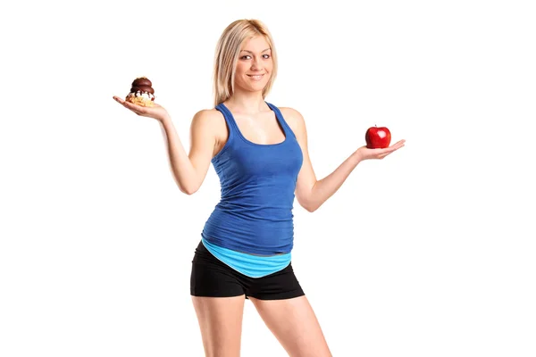 Mujer sosteniendo una manzana y pastel —  Fotos de Stock