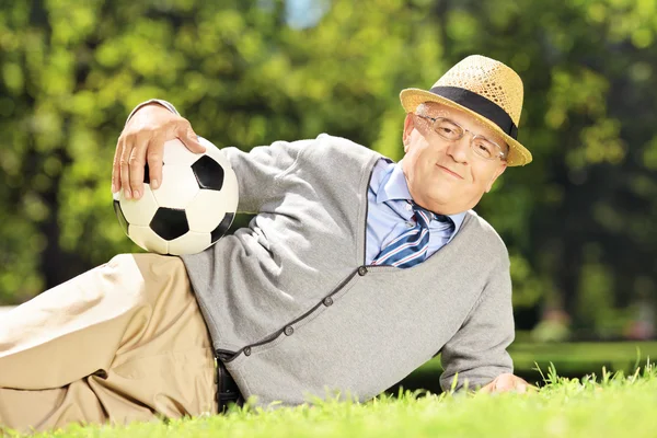 Homem sênior na grama com bola — Fotografia de Stock