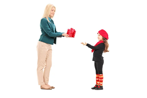 Женщина дарит подарок маленькой девочке — стоковое фото