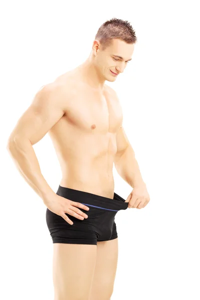Young shirtless man looking in his pants — Stock Photo, Image