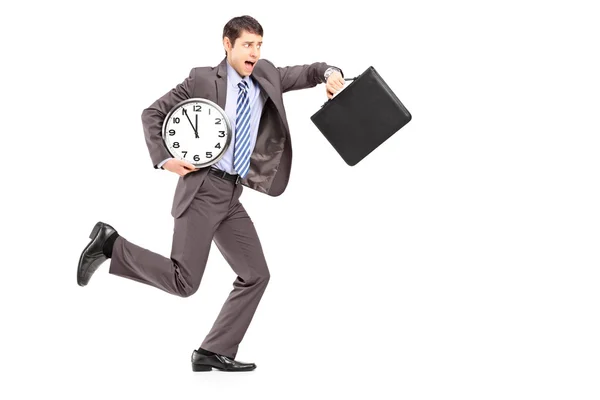 Businessman running late with clock — Stock Photo, Image