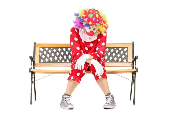 Trauriger Clown sitzt auf Bank — Stockfoto