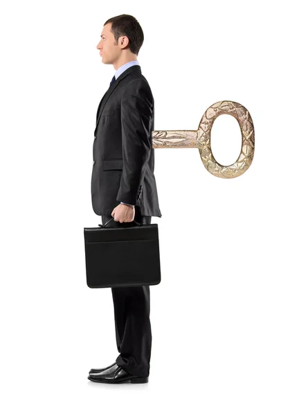 Businessman with wind-up key in back — Stock Photo, Image