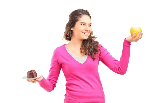 Mujer sosteniendo una manzana y pastel — Foto de Stock