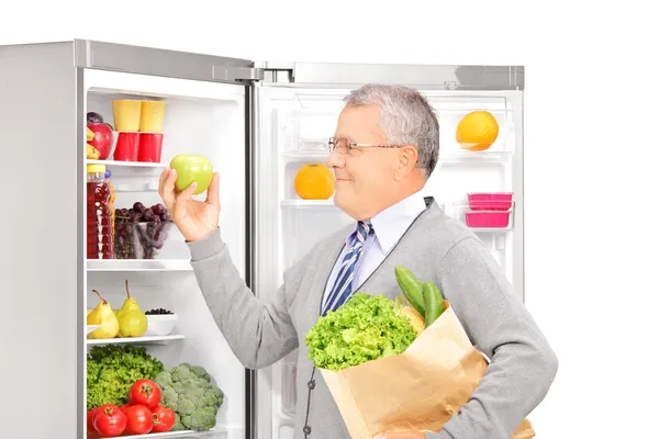 Mature man near the refrigerator — Stock Photo, Image