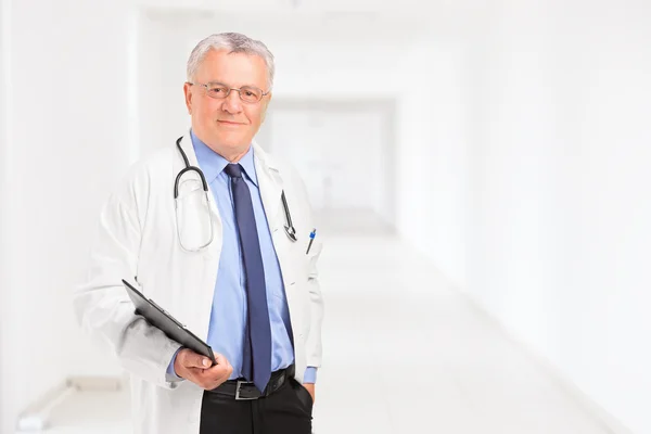 Mandlig læge stående i hospitalshallen - Stock-foto