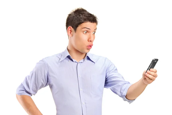 Confused young male looking at mobile phone — Stock Photo, Image