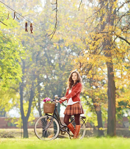 Bisiklet ile genç kadın ayakta — Stok fotoğraf