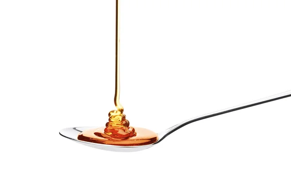 Honey falling on spoon — Stock Photo, Image