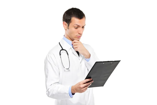 Medical doctor looking at clipboard — Stock Photo, Image