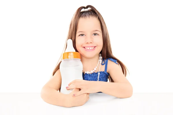Girl holding huge baby bottle — Stock Photo, Image