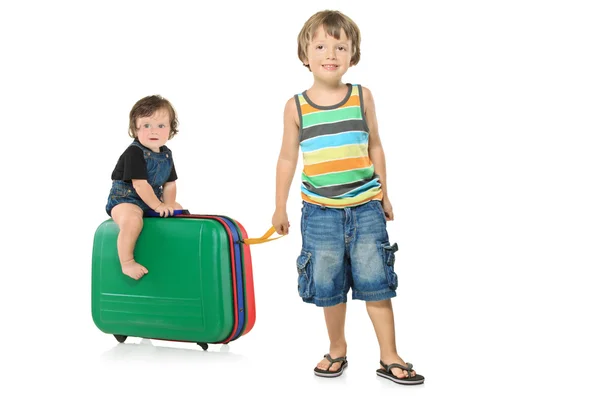 女の赤ちゃんのスーツケースを引いて少年 — ストック写真