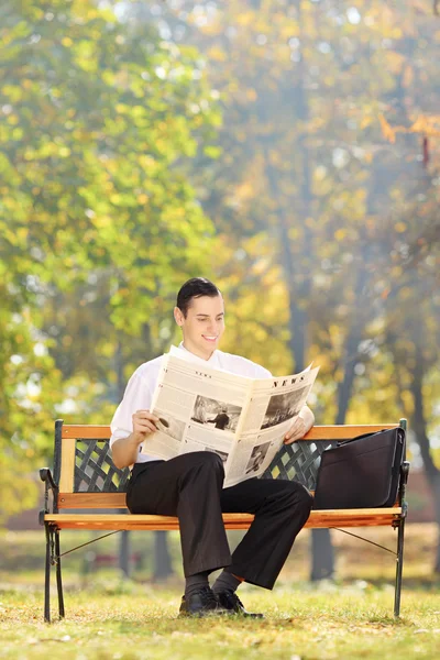Empresario leyendo periódico en parque — Foto de Stock