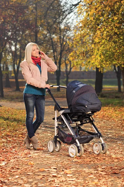 Moeder op telefoon tijdens wandeling met baby — Stockfoto