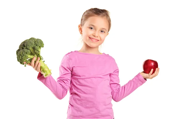 Niño sosteniendo brócoli y manzana —  Fotos de Stock