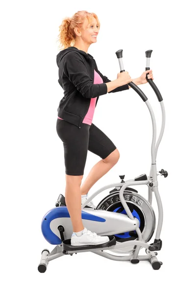 Woman excersing on cross trainer — Stock Photo, Image