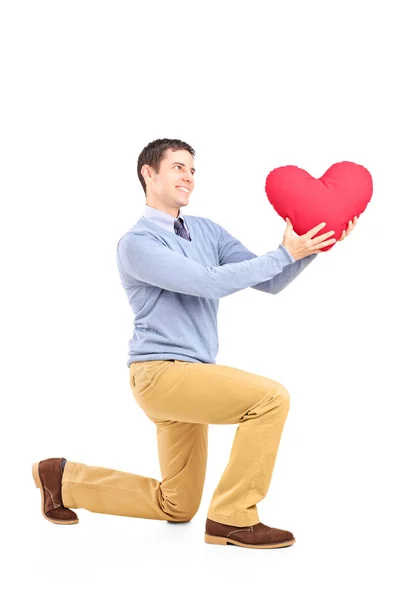 Muž klečí s červeným srdcem — Stock fotografie