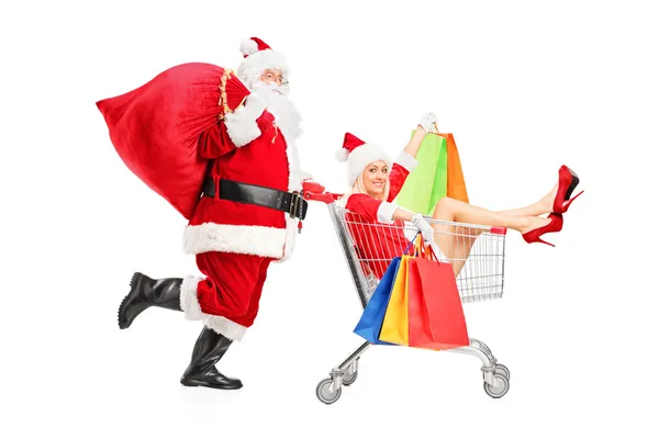 Santa Claus empujando bolsa de compras en el carrito — Foto de Stock