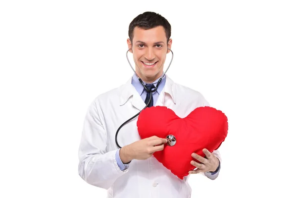 Médecin examinant oreiller en forme de coeur — Photo