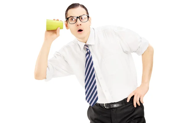 Hombre escuchando a través de la pared con una taza — Foto de Stock