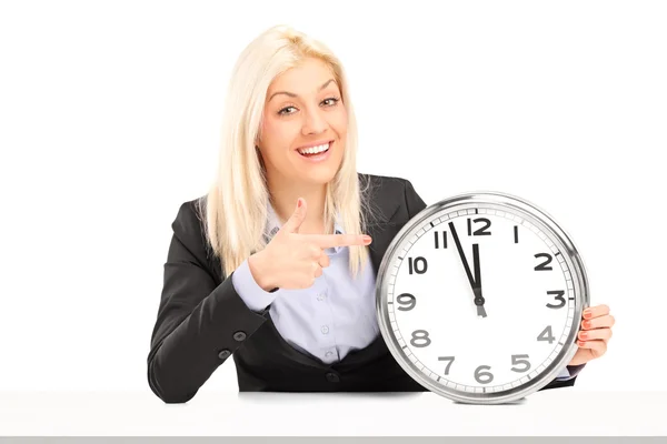 Mujer de negocios señalando en el reloj de pared — Foto de Stock