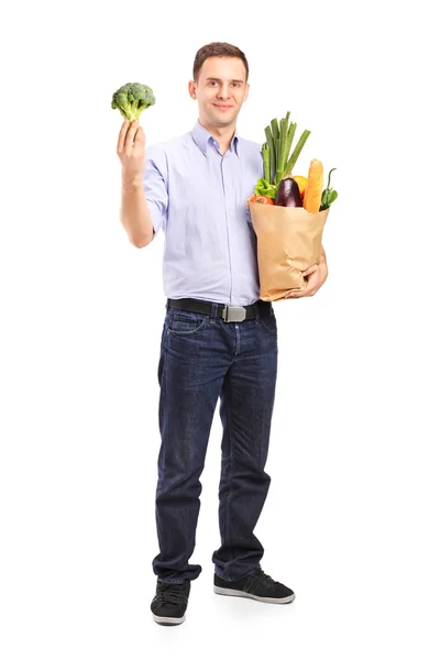 Hombre sosteniendo bolsa de compras con productos —  Fotos de Stock