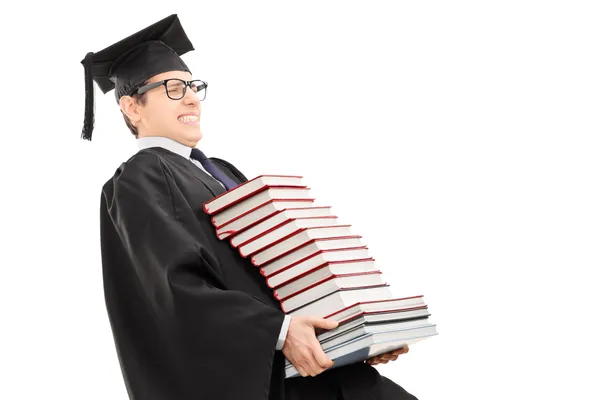 Homem de vestido de graduação carregando livros — Fotografia de Stock