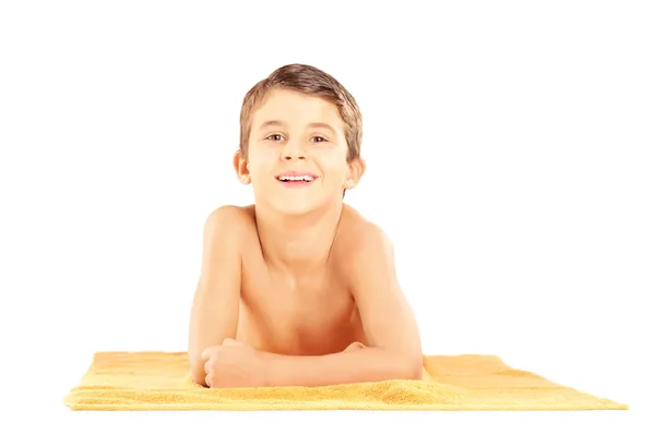 Child lying on beach towel — Stock Photo, Image