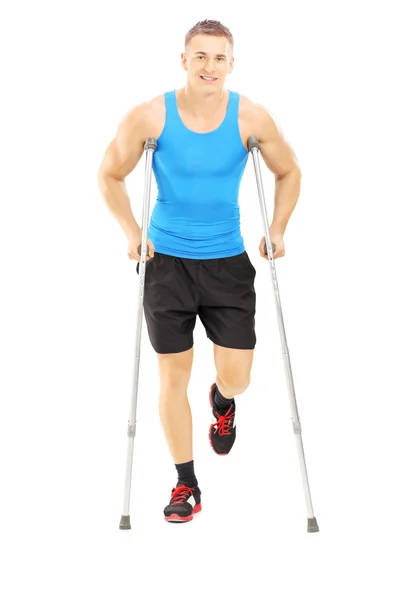 Injured male athlete with crutches — Stock Photo, Image