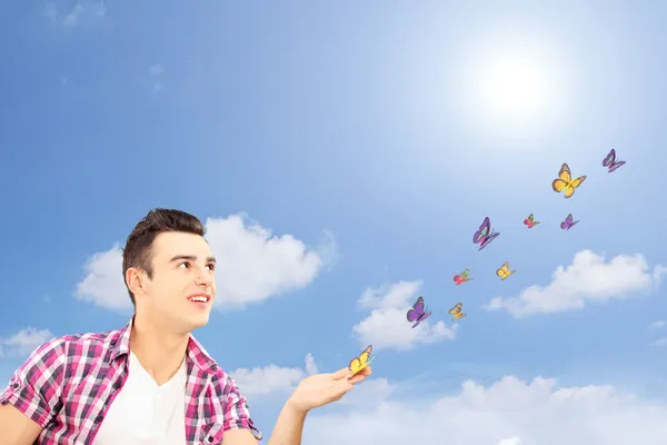 Handsome guy looking at butterflies — Stock Photo, Image