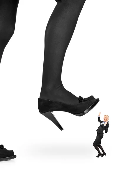 Женщина ботинок наступает на деловую женщину — стоковое фото
